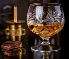 Chocolate with brandy on dark background