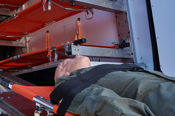 Mannequin in military uniform on a stretcher against the background of a medical machine for evacuating the wounded from the battlefield