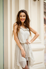 Portrait close up of young beautiful brunette woman in beige dress