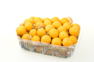 Many Cape Gooseberry in a plastic tray. On white background.