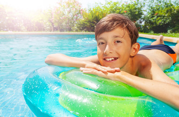 Happy teen boy sunbathing on inflatable mattress