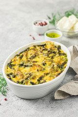 Cheesy green bean casserole in a baking dish. Selective focus, space for text.