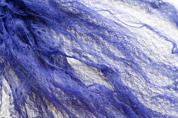 Background. An abstract pattern on fabric. Waves, knitted, wattled scarf. Folds, drapery, silk.