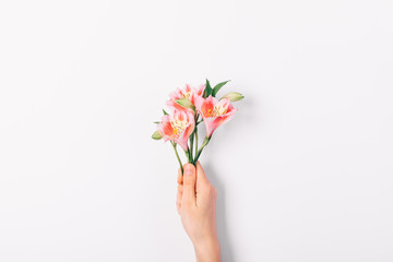 Small pink bouquet of lilies in woman's hand