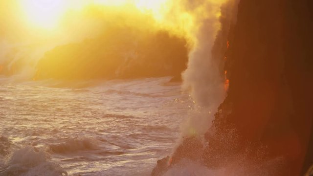 Red hot lava falling into ocean at sunrise causing rising steam seen from distance Hawaii slow motion Kilauea Big Island USA 