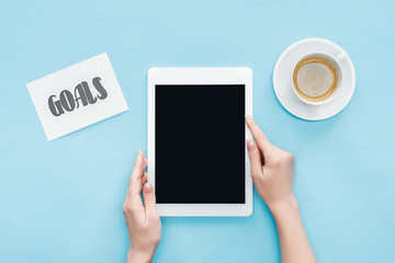 cropped view of female holding digital tablet with blank screen ob blue background