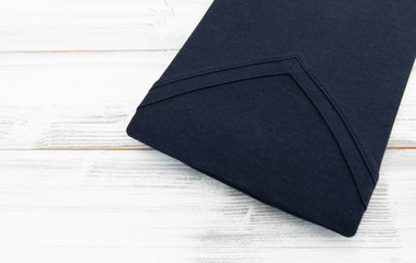 New black v neck shirt on white wooden background