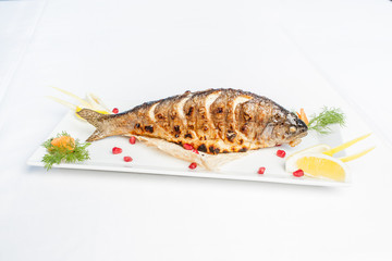 Baked fish on a plate on a white background