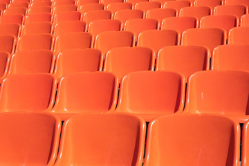Obraz premium plastic chairs for spectators outside the room orange