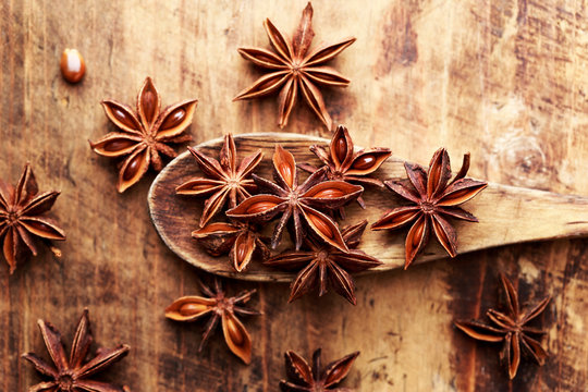 Anise stars on wood spoon close-up