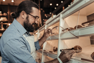 Delighted nice man taking a fresh croissant