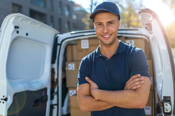 Delivery man standing in front of his van