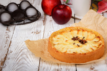 Traditional holiday apple pie. Baked dessert with anise, cloves and apples on light wooden...