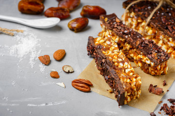 Raw vegan energy bars with dates and nuts and chocolate frosting. Homemade healthy snack sweets.