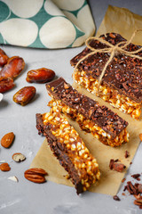 Raw vegan energy bars with dates and nuts and chocolate frosting. Homemade healthy snack sweets.