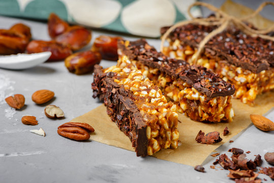 Raw vegan energy bars with dates and nuts and chocolate frosting. Homemade healthy snack sweets.