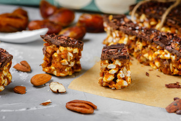 Raw vegan energy bars with dates and nuts and chocolate frosting. Homemade healthy snack sweets.