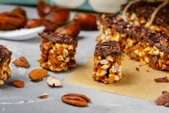 Raw vegan energy bars with dates and nuts and chocolate frosting. Homemade healthy snack sweets. - Powered by Adobe