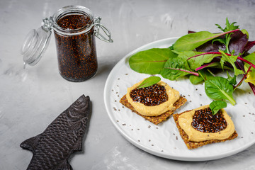 Vegan caviar made with chia seeds and nori. Appetizers on whole grain crispbreads  with hummus