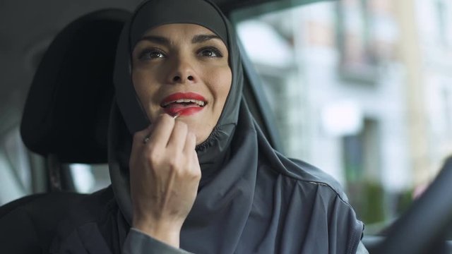 Attractive Sexy Lady In Hijab Applying Red Lipstick In Automobile Feminism, Kiss