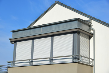 Glasfenster über Eck mit Rolladen an modernem Wohngebäude