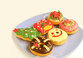 Various Design of Colorful Christmas Decorated Doughnuts Sweets on Light Blue Plate with Free Space for Text or Design 
