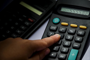 calculators and a hand on a white background