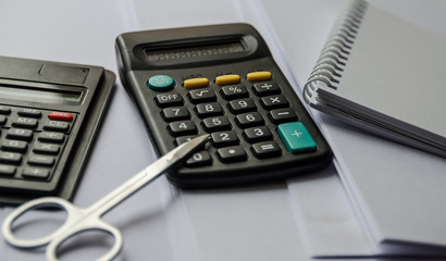 calculators and scissors and a notepad on a white background