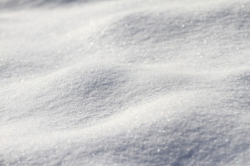 Snow. Fresh white snow surface. Winter snow texture. Snow background and wallpaper. Bright light in the snow. Snowflakes. 