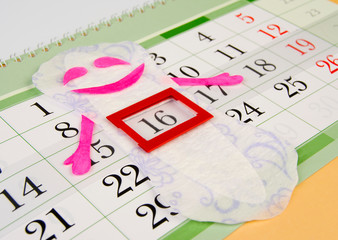 women's sanitary napkin is on the calendar and indicates the beginning of the menstrual cycle. The concept of women's health.