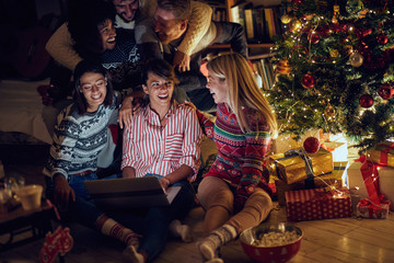 group of friends watching movie on laptop on Christmas eve.