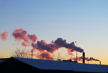 Fototapeta na wymiar City evening landscape with factory pipes at sunset.