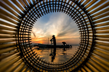 Image is silhouette. Fishermen Casting are going out to fish early in the morning with wooden boats, old lanterns and nets. Concept Fisherman's life style.