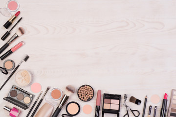 Makeup cosmetics such as eyeshadows, lipstick, mascara and makeup accessories on white, wooden...