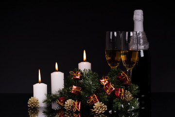 Two glasses with champagne, candles and Christmas decoration