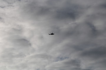 Cielo nuvoloso con silhouette di elicottero in volo