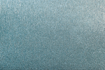 Textural of turquoise background of wavy corrugated paper, closeup.