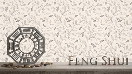 Wooden vintage table shelf with ba gua and 3d letters making the word feng shui with abstract leaves background with copy space, zen concept interior design