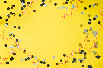 Birthday party background. Yellow table with confetti and ribbon. Place for text.