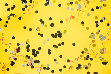 Birthday party background. Yellow table with confetti and ribbon.