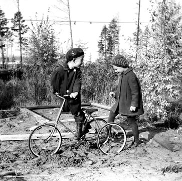 Boy and girl with bicycle outdoors 