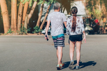 Back view of people walking on the hiking trail in the woods to