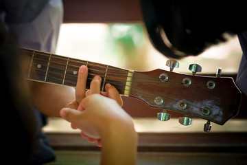 Secondary school students are learning how to play guitar in sch