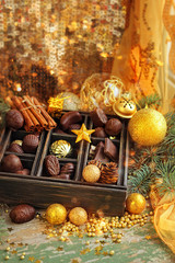 festive still life with chocolate candy  in Christmas decorations. selective soft focus, toning