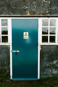 Blue door with a hazardous substances sign on it
