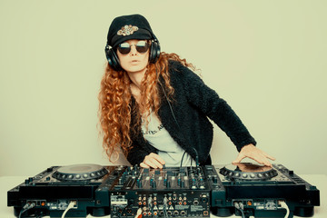 Portrait of curly hair young DJ playing music on light background