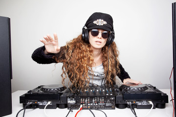 Portrait of curly hair young DJ playing music on light background
