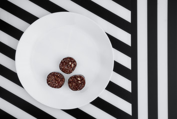 Black pudding on black and white striped background. Morcilla de Burgos