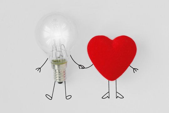 Light Bulb And Heart Holding Hands - Concept Of Brain And Heart Teamwork