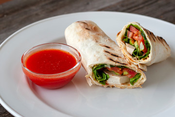 Healthy diet. Vegetarian wrap with tofu, hummus and hot sauce. Part of: lettuce, tomato, cheese and pita bread.